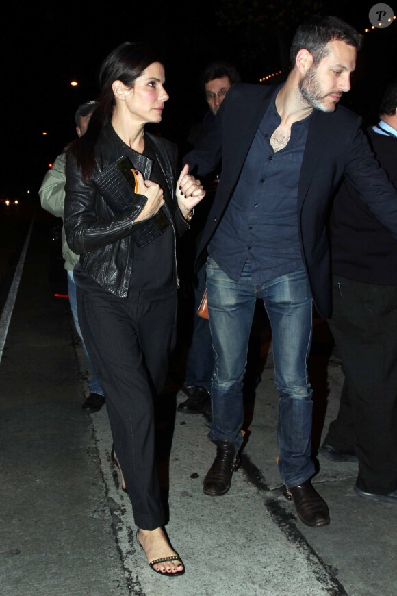 Sandra Bullock et un mystérieux inconnu très protecteur quittent Craig's à West Hollywood, Los Angeles, le 12 mars 2014.