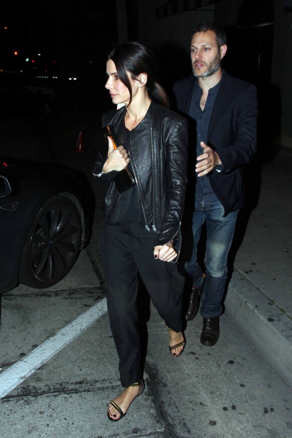 Sandra Bullock et un mystérieux inconnu très protecteur (mais marié vu l'alliance qu'il porte) quittent Craig's à West Hollywood, Los Angeles, le 12 mars 2014.