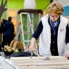 La princesse Margriet des Pays-Bas aide à vernir du mobilier à Zeewolde, sur un site de l'Institut pour l'Education environnementale et le développement durable, le 21 mars 2014 pour la 10e Journée du bénévolat organisée par le Fonds Orange.
