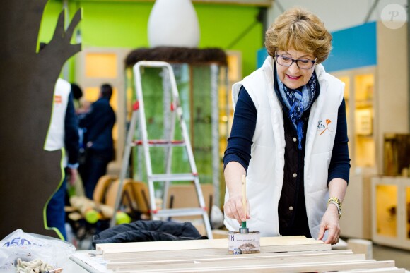 La princesse Margriet des Pays-Bas aide à vernir du mobilier à Zeewolde, sur un site de l'Institut pour l'Education environnementale et le développement durable, le 21 mars 2014 pour la 10e Journée du bénévolat organisée par le Fonds Orange.