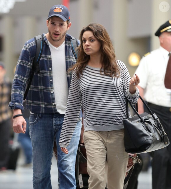 Exclusif - Mila Kunis (enceinte) et son fiancé Ashton Kutcher à l'aéroport de La Nouvelle-Orléans. Le 19 avril 2014.