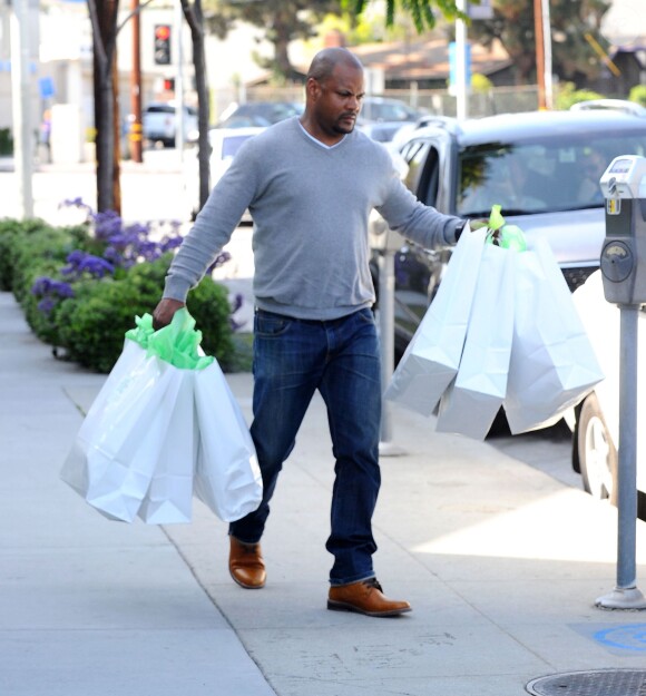Le garde du corps de Rihanna porte ses sacs Petit Tresor à l'issue de sa séance shopping. West Hollywood, le 22 avril 2014.