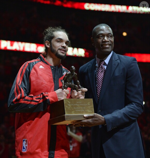 Joakim Noah reçoit le titre de défenseur de l'année des mains de Dikembe Mutombo, titré quatre fois, avant son match contre les Washington Wizards avec les Chicago Bulls à Chicago, le 22 avril 2014. 