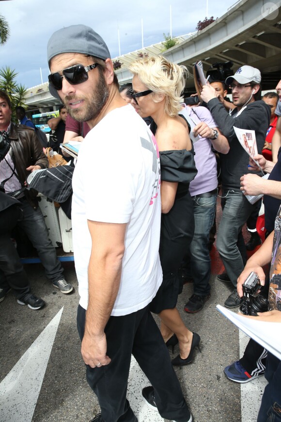 Pamela Anderson, attendue par de nombreux fans à qui elle a signé des autographes, arrive avec son mari Rick Salomon à l'aéroport de Nice pour le festival de Cannes, le 13 mai 2014.