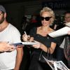 Pamela Anderson, attendue par de nombreux fans à qui elle a signé des autographes, arrive avec son mari Rick Salomon à l'aéroport de Nice pour le festival de Cannes, le 13 mai 2014.