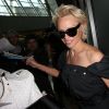 Pamela Anderson, attendue par de nombreux fans à qui elle a signé des autographes, arrive avec son mari Rick Salomon à l'aéroport de Nice pour le festival de Cannes, le 13 mai 2014.