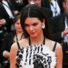 Kendall Jenner, habillée d'une robe (collection croisière 2014) et d'une pochette Chanel, de bijoux Chopard et de sandales Stuart Weitzman, monte les marches pour la cérémonie d'ouverture du 67e Festival de Cannes et la projection du film Grâce de Monaco. Cannes, le 14 mai 2014.