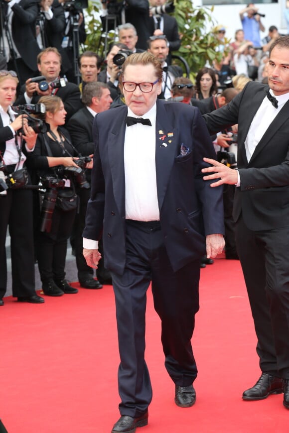 Helmut Berger vacillant pendant la montée des marches du film "Saint-Laurent" lors du 67e festival international du film de Cannes - 17 mai 2014