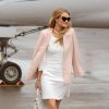 Exclusif - Rosie Huntington-Whiteley arrive à Cannes en jet privé, habillée d'une veste pêche, d'une charmante petite robe blanche, d'un sac Dolce & Gabbana (modèle Sicily) et de souliers Christian Louboutin (modèle Galata). Le 19 mai 2014.