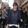 Lily Allen, à Londres, accessoire sa tenue bleu marine et blanche de lunettes et de baskets Céline, et d'une pochette en peau de reptile Chanel. Le 22 mai 2014.