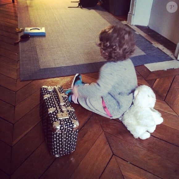 La petite Romy, 16 mois, fille de la chanteuse Coeur de Pirate, avec son doudou et sa mini-valise.