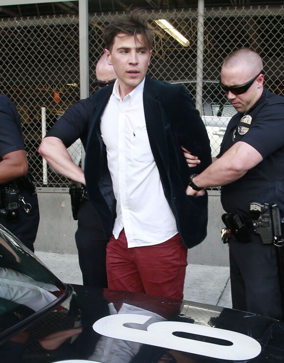 Le journaliste ukrainien Vitalii Sediuk, connu pour ses apparitions impromptues sur les tapis rouges, arrêté et menotté par les policiers sur le tapis rouge de "Maléfique" après avoir agressé Brad Pitt à Los Angeles le 28 mai 2014.
