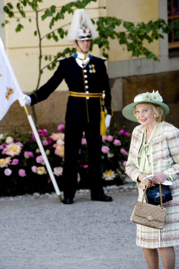 Marianne Bernadotte passe devant un garde lors du baptême de la princesse Leonore de Suède, au palais Drottningholm à Stockholm, le 8 juin 2014, au cours duquel deux gardes ont perdu connaissance.