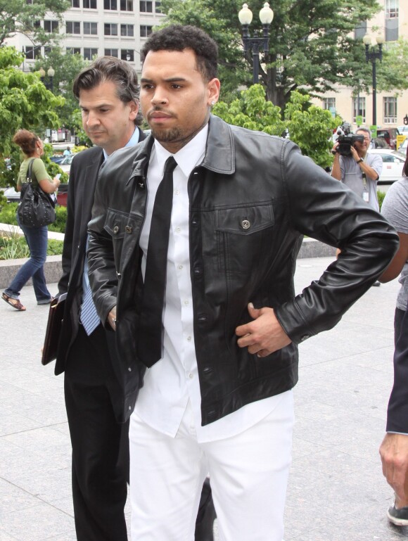 Chris Brown, tout de noir et blanc vêtu, arrive au tribunal de Washington D.C. Le 25 juin 2014.