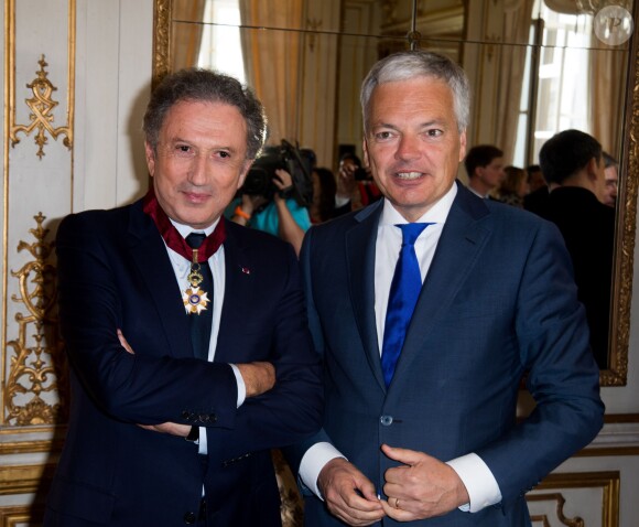 Didier Reynders (Vice-Premier Ministre et Ministre des Affaires étrangères) et Michel Drucker, à l'occasion de la cérémonie de remise des insignes de commandeur de l'Ordre de la Couronne à Michel Drucker au palais d'Egmont à Bruxelles le 27 juin 2014.