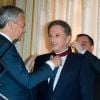 Didier Reynders (Vice-Premier Ministre et Ministre des Affaires étrangères) et Michel Drucker, à l'occasion de la cérémonie de remise des insignes de commandeur de l'Ordre de la Couronne à Michel Drucker au palais d'Egmont à Bruxelles le 27 juin 2014.