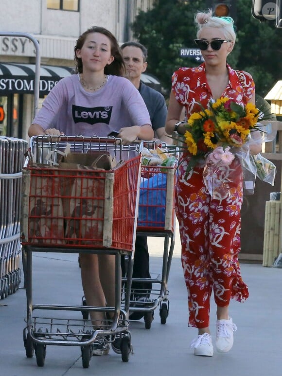 Exclusif - Miley Cyrus et sa soeur Noah vont faire des courses à Los Angeles, le 29 juin 2014. Miley porte son nouveau petit chien Emu dans ses bras.