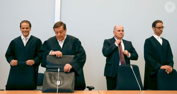 Uli Hoeness, le président du Bayern de Munich, entouré de ses avocats au troisième jour de son procès pour fraude fiscale au palais de justice de Munich, le 12 mars 2014