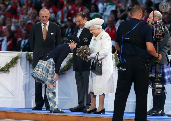 La reine Elizabeth II reçoit un bouquet lors de la cérémonie d'ouverture des Jeux du Commonwealth 2014, le 23 juillet au Celtic Park de Glasgow.
