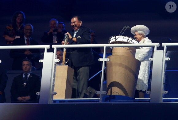 La reine Elizabeth II regarde avec amusement le prince Imran lutter pour ouvrir le bâton des Jeux lors de la cérémonie d'ouverture des Jeux du Commonwealth 2014, le 23 juillet au Celtic Park de Glasgow.