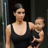 Kim Kardashian et sa fille North, habillées de robes noires, quittent leur appartement à SoHo. New York, le 12 août 2014.