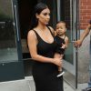 Kim Kardashian et sa fille North, habillées de robes noires, quittent leur appartement à SoHo. New York, le 12 août 2014.
