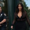 Kim Kardashian, reluquée par un policier (à gauche) à sa sortie de son appartement. New York, le 11 août 2014.