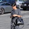 Rihanna, entièrement habillée en Alexander Wang (t-shirt en pantalon rayés de la pré-collection automne 2014, chaussures de la collection croisière 2013) et portant un sac Delvaux, quitte le restaurant Le Petit Four à West Hollywood. Le 12 août 2014.