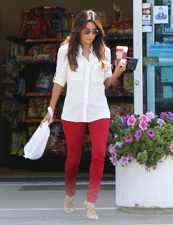 Exclusif - Eva Longoria de sortie à Hollywood, porte des lunettes de soleil Ray-Ban, une chemise blanche, un jean rouge J Brand et des sandales Jimmy Choo (modèle Lance). Le 13 août 2014.