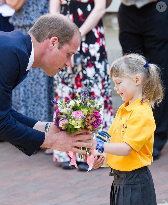 Le prince William accueilli par une fillette lors de sa visite à l'Université d'Oxford le 8 septembre 2014, le jour de l'annonce de la seconde grossesse de son épouse Kate Middleton. Malade, la duchesse n'a pas pu faire le déplacement.