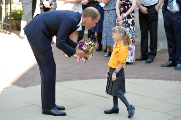 Le duc de Cambridge avec la petite Bethlily Barton lors de sa visite à l'Université d'Oxford le 8 septembre 2014, le jour de l'annonce de la seconde grossesse de son épouse Kate Middleton. Malade, la duchesse n'a pas pu faire le déplacement.