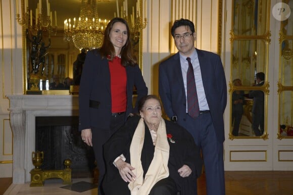 L'ex-ministre de la culture Aurelie Filippetti remet les insignes de Chevalier de l'ordre national de la Legion d'Honneur à Gaby Aghion, fondatrice de Chloé, en présence de son fils Phillipe. Paris, décembre 2013.