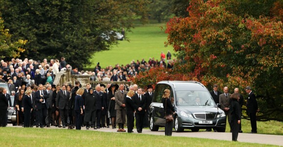 Le prince Charles et Camilla Parker Bowles en tête de cortège derrière la famille lors des funérailles de Deborah Cavendish, née Mitford, duchesse douairière du Devonshire, le 2 octobre 2014 à Chatsworth.