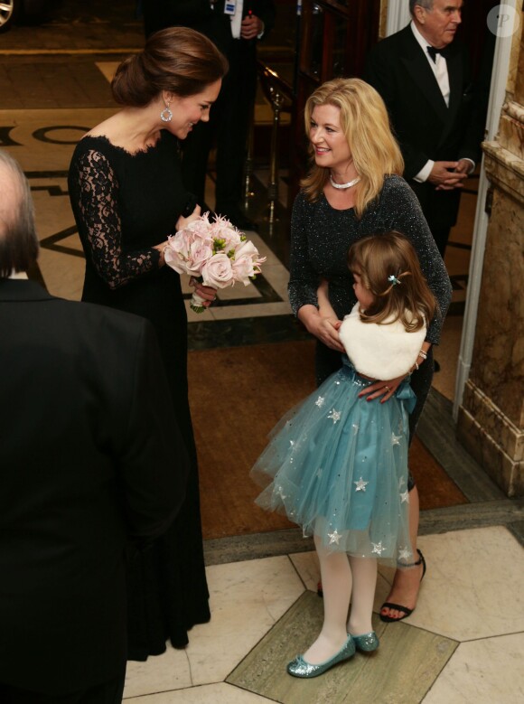 Kate Middleton, enceinte et sublime dans une robe Diane von Furstenberg, qui reçoit ici des fleurs à son arrivée, et le prince William assistaient le 13 novembre 2014, pour la première fois, à la Royal Variety Performance au Théâtre Palladium, à Londres.