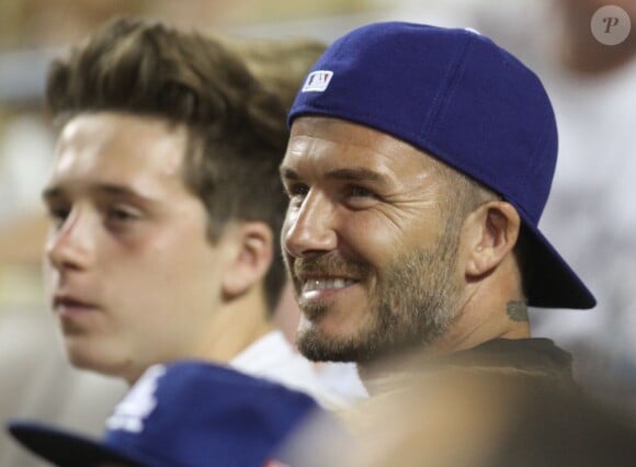 Brooklyn Beckham et son père David Beckham assistent au match de baseball des Los Angeles Dodgers au Dodger stadium à Los Angeles, le 1er août 2014.