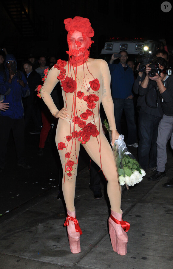 Lady Gaga de sortie à New York pour son anniversaire, porte un masque rouge en dentelle ERENFIDANCI, une combinaison nude transparente et couverte de roses, et des chaussures Long Tran. Le 28 mars 2014.
