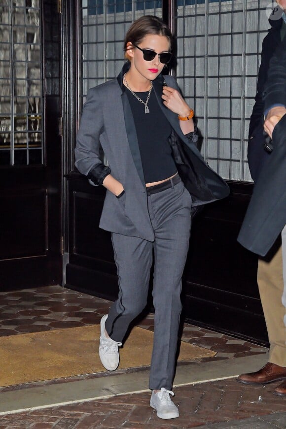 Kristen Stewart de sortie à New York, porte un costume gris ardoise à revers et liserets noirs, un top noir, un sac Chanel et des baskets Vans. Le 15 janvier 2015.