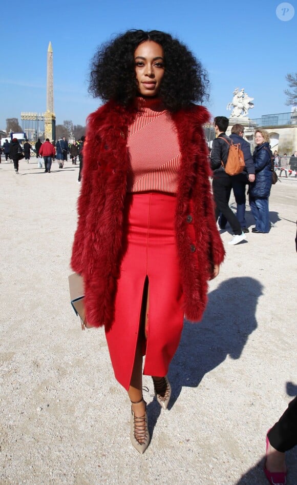 Solange Knowles lors du défilé Carven automne-hiver 2015/2016 à Paris, porte un manteau en fourrure, un pull et une jupe Carven (pré-collection automne 2015), un sac M2 Malletier et des sandales lacées. Paris, le 5 mars 2015.