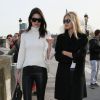 Kendall Jenner et Gigi Hadid à la sortie de la cathédrale Notre-Dame de Paris. Kendall porte des lunettes et un sac Céline, un sweater blanc, un pantalon en cuir Balenciaga et des bottines Saint Laurent. Le 6 mars 2015.