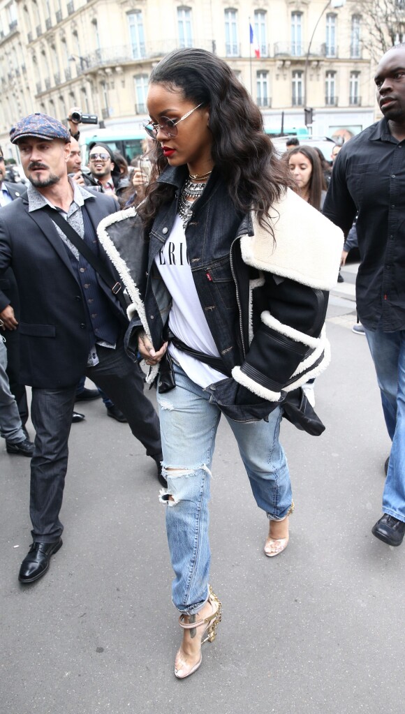 Rihanna arrive au restaurant l'Avenue à Paris, habillée d'une veste (collection automne-hiver 2015-2016) et des sandales Dsquared&sup2; (modèle Virginia), d'une veste en jean Levi's, d'un t-shirt Brashy et d'un jean usé. Le 9 mars 2015.