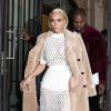 Kanye West et sa femme Kim Kardashian, tout de Balenciaga vêtue avec un manteau camel (pré-collection automne 2015), un ensemble t-shirt et jupe et des sandales en satin (collection printemps-été 2015), quittent le Royal Monceau à Paris. Le 6 mars 2015.