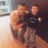 Ryan Reynolds montre ses muscles au côté d'un petit garçon. (photo postée le 30 mars 2015)