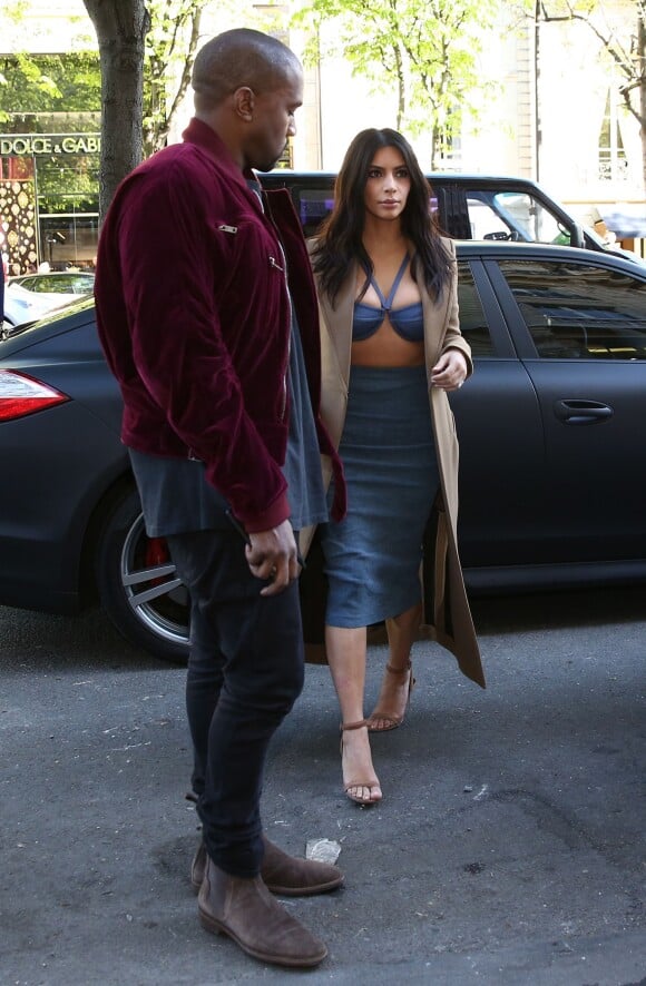 Kanye West et Kim Kardashian, habillée d'un manteau Céline (collection automne-hiver 2013-2014), d'un soutien-gorge et d'une jupe bleuets, et de sandales Alexander Wang (modèle Antonia) arrivent au Montaigne Market à Paris. Le 14 avril 2015.