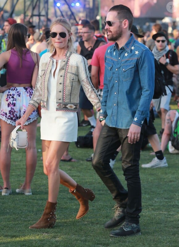 Kate Bosworth, vêtue d'une veste Etro, d'une robe blanche Kempner, d'un sac Coach (modèle Dakotah) et de bottines de sa collection pour Matisse (modèle Charlotte), assiste au festival de Coachella avec son mari Michael Polish. Indio, le 11 avril 2015.