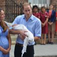  Kate Middleton et le prince William pr&eacute;sentant le prince George de Cambridge devant la maternit&eacute; de l'h&ocirc;pital St Mary, le 23 juillet 2013, au lendemain de sa naissance. 