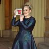 La chanteuse Adele (Adele Adkins) pose avec sa medaille (MBE), apres avoir ete decoree par le prince Charles, prince de Galles pour ses talents musicaux lors d'une ceremonie au palais de Buckingham a Londres, le 19 decembre 19, 2013.19/12/2013 - Londres