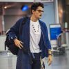 John Mayer, qui porte une robe de chambre bleue, arrive à l'aéroport de New York en provenance de la Corée du Sud où il a donné un concert, le 11 mai 2014. 