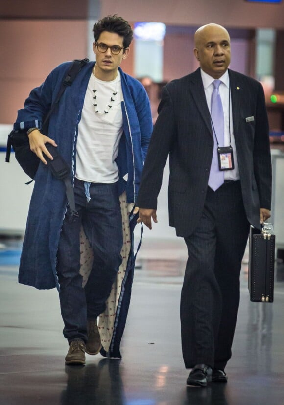 John Mayer, qui porte une robe de chambre bleue, arrive à l'aéroport de New York en provenance de la Corée du Sud où il a donné un concert, le 11 mai 2014. F