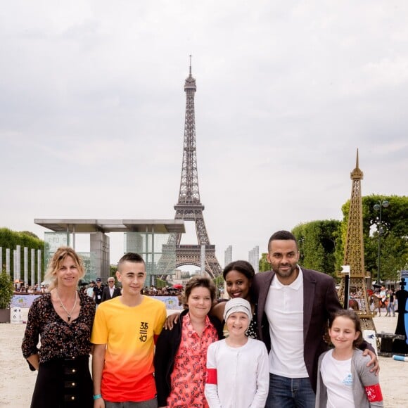 Tony Parker et Virginie Coupérie-Eiffel avec les enfants de la Kids Cup présentée par l'association "Sourire à la vie" lors du Paris Eiffel Jumping du Longines Global Champions Tour, le 5 juillet 2015 sur le Champs-de-Mars à Paris