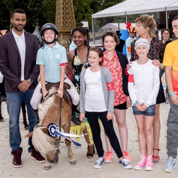 Tony Parker et Virginie Coupérie-Eiffel avec les enfants de la Kids Cup présentée par l'association "Sourire à la vie" lors du Paris Eiffel Jumping du Longines Global Champions Tour, le 5 juillet 2015 sur le Champs-de-Mars à Paris